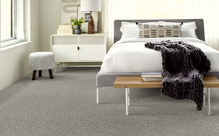 grey carpet in bedroom with white sheets